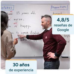Fotografía de uno de nuestros profesores nativos titulados explicando a una alumna con la pizarra. La alumna está participando. Sobre la foto, unos gráficos indican que tenemos 4.8/5 estrellas en Google y 30 años de experiencia desde que la academia Seif se fundó en 1993.