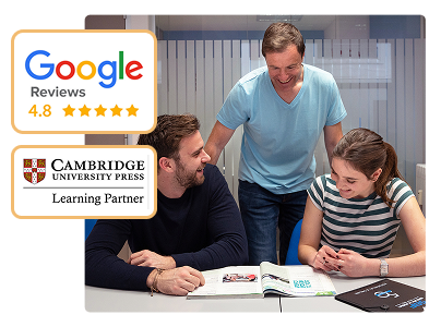 Profesor sonriente enseñando a dos alumnos adultos que estudian inglés juntos en un aula moderna. En la imagen se destacan las valoraciones de Google con 4.8 estrellas y el sello de socio de Cambridge University Press, porque nuestra academia es centro preparador oficial.